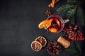 Traditional Christmas warming mulled wine. Hot drink with spices in glass cup on dark background