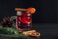 Traditional Christmas warming mulled wine. Hot drink with spices in glass cup on dark background