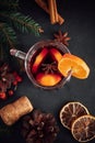 Traditional Christmas warming mulled wine. Hot drink with spices in glass cup on dark background