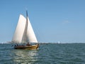 Traditional classic sailboat sailing under full sails on IJsselmeer lake, Netherlands