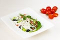 Traditional classic Shopska salad with tomatoes, peppers, cucumbers and cheese in white dish on white wooden table. Bulgarian cuis Royalty Free Stock Photo