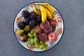 A traditional clay bowl with a lot of different summer fruit