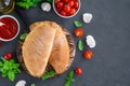 Traditional closed Italian calzone pizza with tomato sauce, mozzarella cheese and mushrooms on a board on a dark background.