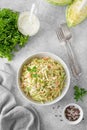 Traditional cole slaw salad in a bowl on a gray concrete background. Salad with cabbage, carrot and mayonnaise sauce.