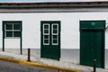 Traditional colonial house with guillotine windows and green door.