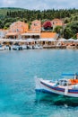 Traditional colorful Greek fishing boat in front of picturesque village, Greece Royalty Free Stock Photo