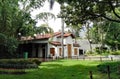 Traditional house with clay tile roof and wooden doors and green area Royalty Free Stock Photo