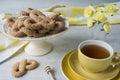 Traditional cookie from The Netherlands called Krakeling, on white cake stand.  yellow cup of tea Royalty Free Stock Photo