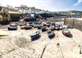 Traditional Cornish fishing boats moored in Coverack harbour with the tide out