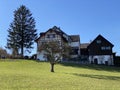 Traditional country houses and old livestock farms along the Bergweiher pond and on the slopes of the Horgenberg hill, Horgen Royalty Free Stock Photo