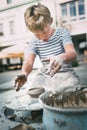 Traditional craft lesson: boy try to make a pottery bowl Royalty Free Stock Photo