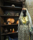 Traditional Crimean Tartar woman costume put on dummy, kitchen utensils on shelves