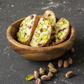 Traditional crispy Italian biscotti or cantuchini crackers with pistachios and dried cranberries in a bowl of olve wood