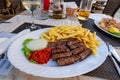 Traditional croatian balkan cevapcici dinner with fies ajvar and onion Royalty Free Stock Photo