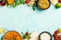 Traditional curry and ingredients on blue background