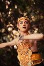 A Traditional dancer with golden clothes and a golden crown posing bravely in the jungle