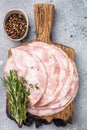 Traditional deli meat (Pancetta) and serving fork on a minimal grey background, perfect for a clean menu Royalty Free Stock Photo