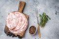 Traditional deli meat (Pancetta) and serving fork on a minimal grey background, perfect for a clean menu Royalty Free Stock Photo