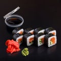 Traditional delicious fresh Syake Kappa sushi roll set on a black background with reflection