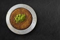 Traditional dessert kunefe with pistachio over black textured background