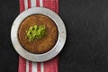 Traditional dessert kunefe with pistachio over black textured background