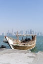 Traditional dhow on a background of a modern city.