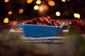 Traditional Dish Of Christmas Pigs In Blankets On Table Set For Meal With Tree Lights In Background