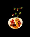 Traditional dish of Mexican cuisine. Corn tortilla tacos with vegetable filling on black background.