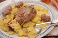 Traditional dish pork shank with potatoes oinon peans in baken on table in restaurant lunch food Royalty Free Stock Photo