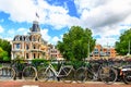 Traditional dutch bicycles parked along the street at Museumbrug bridges over canal. Amsterdam in summer, Netherlands, Europe. Royalty Free Stock Photo