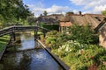 Traditional dutch brick houses with lush green lawns on a water canal in Giethoorn village, Netherlands