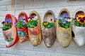 Traditional dutch clogs klompen wooden shoes as very colorful flower pots on brick wall background.