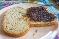 Traditional Dutch hagelslag chocolate sugar sprinkles on whole wheat slice of bread with peanut butter, considered a breakfast