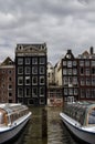 Traditional dutch medieval buildings in along the canal side and parked pleasure boats .Amsterdam, Netherlands. Royalty Free Stock Photo