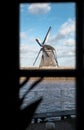 Traditional dutch windmill near the canal. Netherlands. Old windmill stands on the banks of the canal, and water pumps. White clou Royalty Free Stock Photo