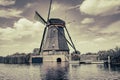 Traditional Dutch windmill in old-fashioned effect with dramatic cloudy sky