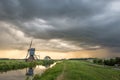 Traditional dutch windmill under a dramatic thundery sky during sundown Royalty Free Stock Photo