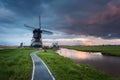Traditional dutch windmills near water canals with cloudy sky, landscape Royalty Free Stock Photo