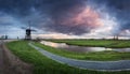 Traditional dutch windmills near water canals with cloudy sky, landscape Royalty Free Stock Photo