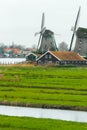 Traditional Dutch windmills and old farm house on river bank Royalty Free Stock Photo