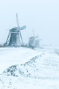 Three traditional Dutch windmills in the snow blue hour Royalty Free Stock Photo