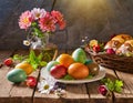 Traditional colored Easter eggs on a wooden table with flowers and bread Royalty Free Stock Photo