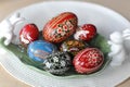 A traditional dyed colourful Easter egg in a basket with feathers in Poland called pisanka or kroszonka