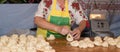 Traditional east european woman in authentic clothing kneading bread dough for