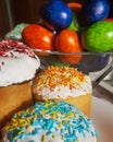 Traditional Easter bread or cake with white glaze and multicolored rainbow sprinkle. and eggs Pysanka. Close up view