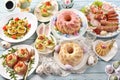 Traditional Easter breakfast with salads, deviled eggs, cold cuts and pastries on blue wooden table Royalty Free Stock Photo