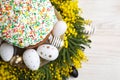 Traditional Easter cake with sprinkles, painted eggs and beautiful spring flowers on white wooden table, top view Royalty Free Stock Photo