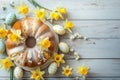 Traditional Easter Gugelhupf cake, complemented by the cheerful yellow of daffodils and patterned Easter eggs. Royalty Free Stock Photo