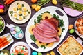 Traditional Easter ham dinner. Above view table scene on a dark wood background.