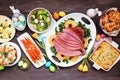 Traditional Easter ham dinner. Top down view table scene on a dark wood background. Royalty Free Stock Photo